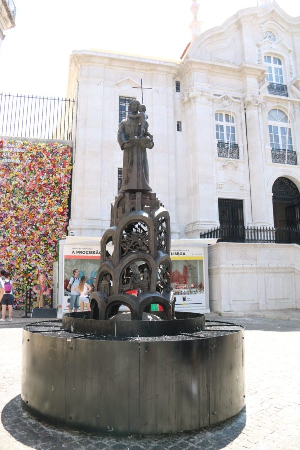 statue of saint anthony in square holding a baby and an open book is great in Lisbon with kids