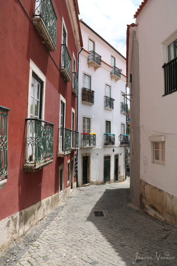 seeing red and white houses with very narrow street in between is great thing to do in Alfama with kids