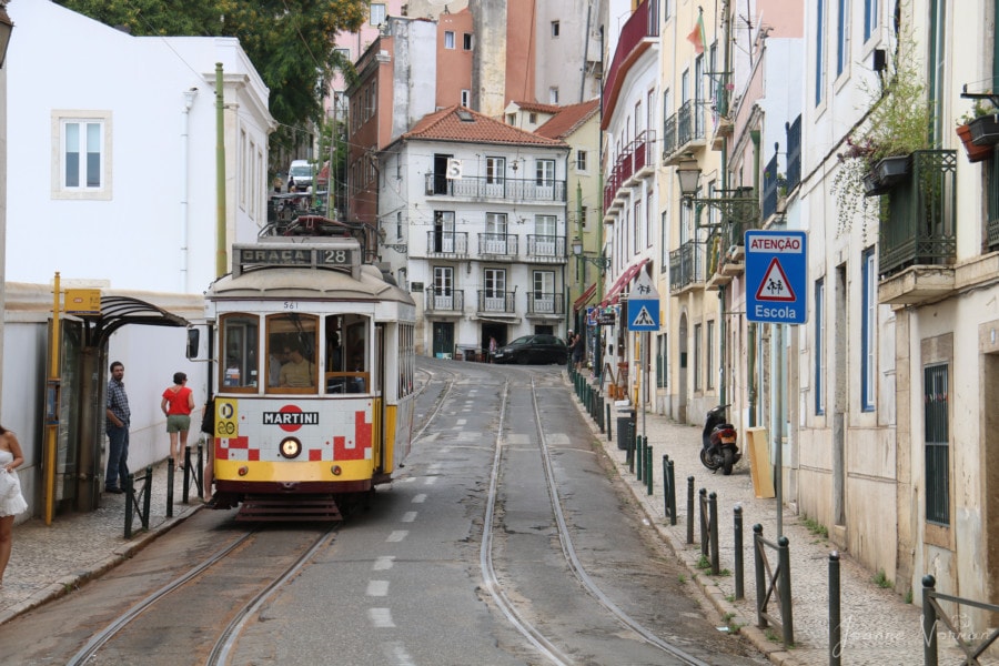 yellow tram number 28 on narrow street in Alfama Lisbon