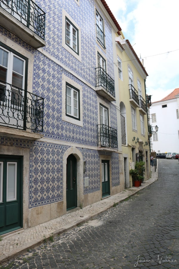tall blue house on narrow road with blue and white tiles is great to place to visit with kids in Alfama