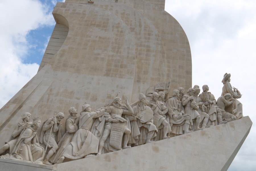 right side of monument of discoveries showing many navigators and explorers in stone carrying different items along boat side is beautiful thing to visit in Belem Lisbon with kids