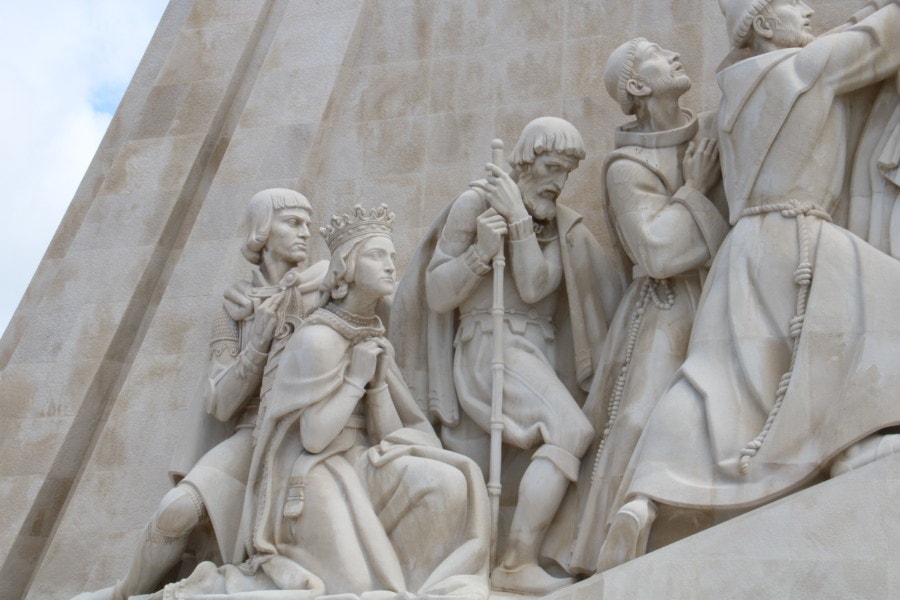 close up of woman on side of monument in white with crown praying