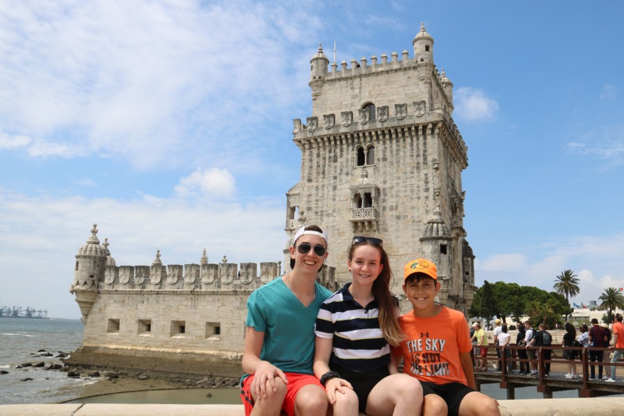 Lisbon with kids sitting in front of Belem tower
