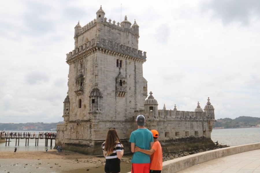 my three kids back on to camera looking at Belem Tower with Caiden having arm around Lucas waist Belem is such a great places with things to do with kids