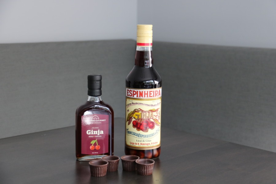 two bottles of ginja one small and one tall on a brown wooden table 