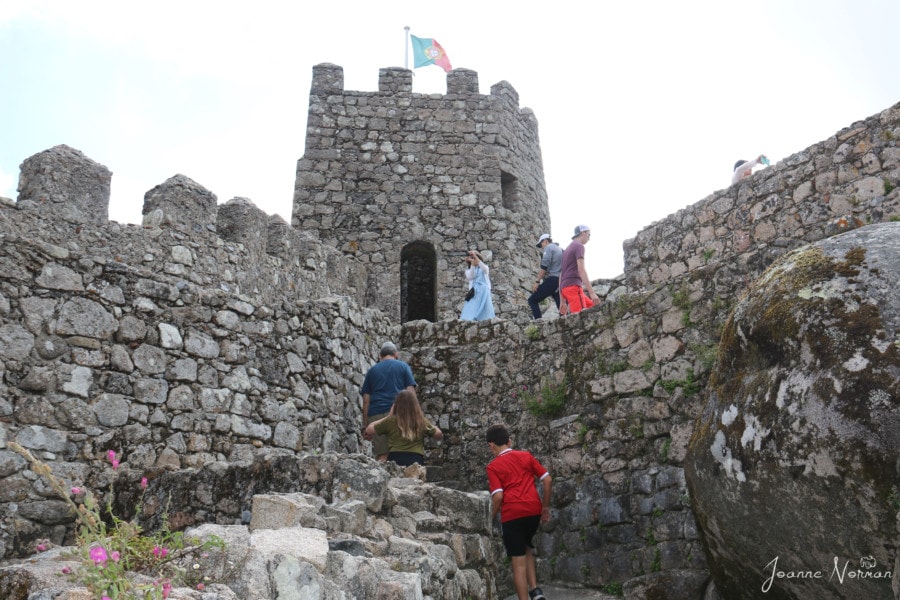 my family walking up stone stairs to walls and stone turrets at Castle of Moors Sintra