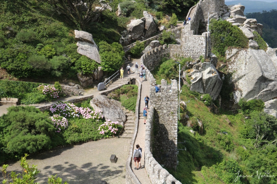 View of daytrip from Lisbon to Sintra at Castle of the Moors showing people walking along the walls