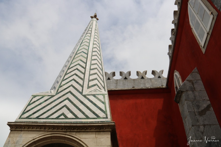 green and white steeple with square red building behind