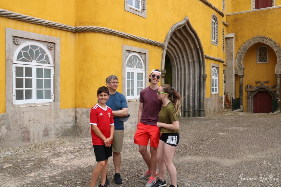 family chatting with yellow building behind