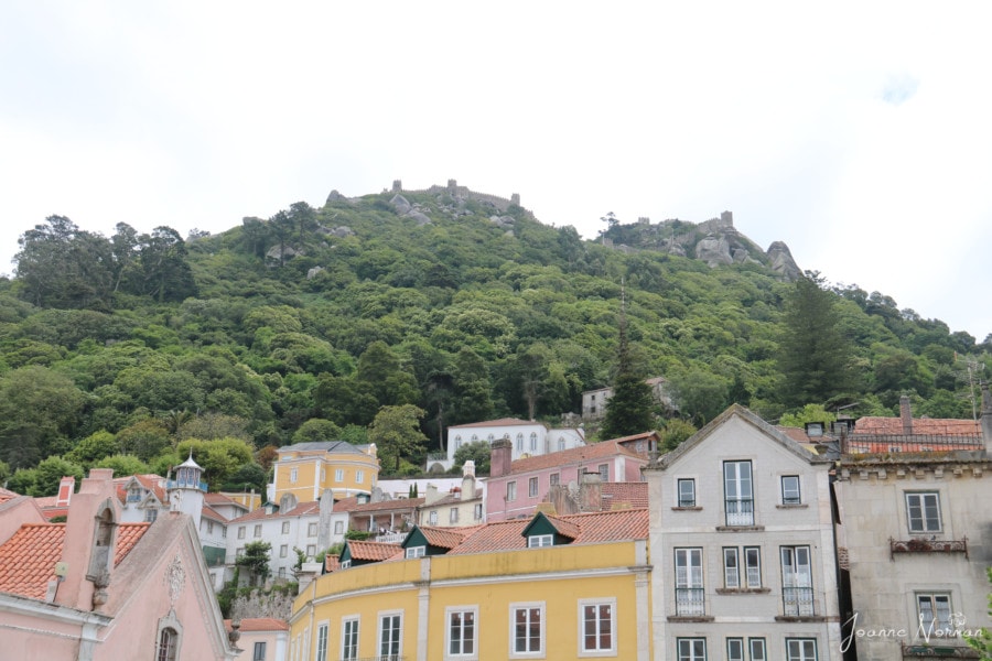 view of pastel houses with Castle of the Moors on top of the hill