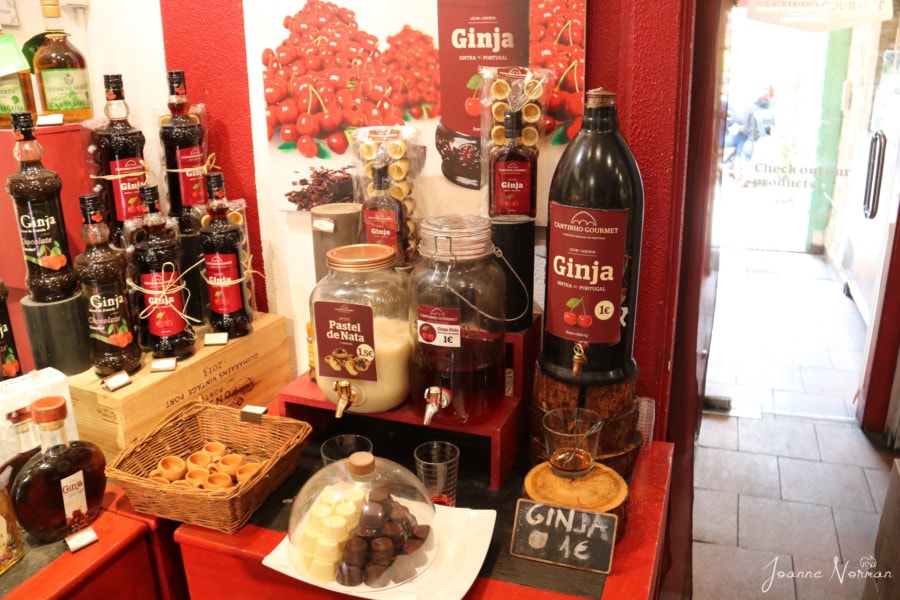 red tray and red wall with two dispensers and many bottles of ginja