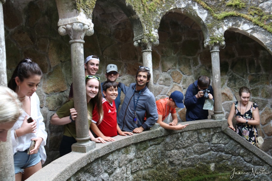 man in blue with my family leaning out of stone archways on daytrip from Lisbon to Sintra