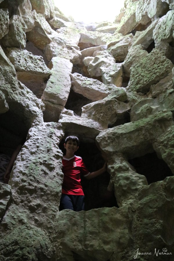 Caiden looking out through opening in cave