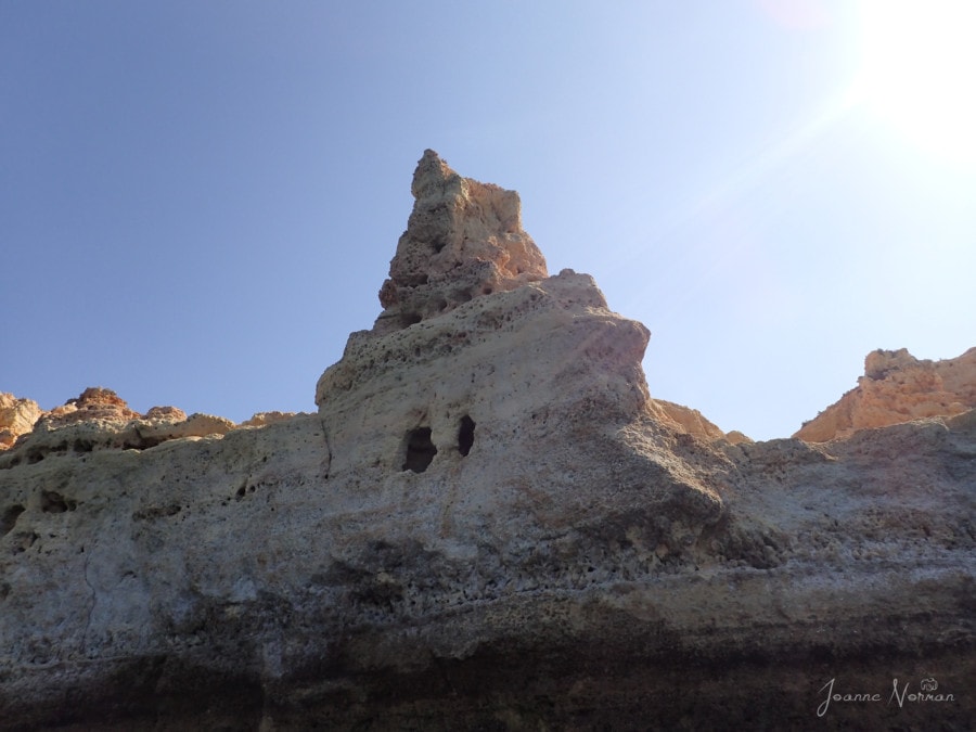 triangle cliff with two open holes in rocks