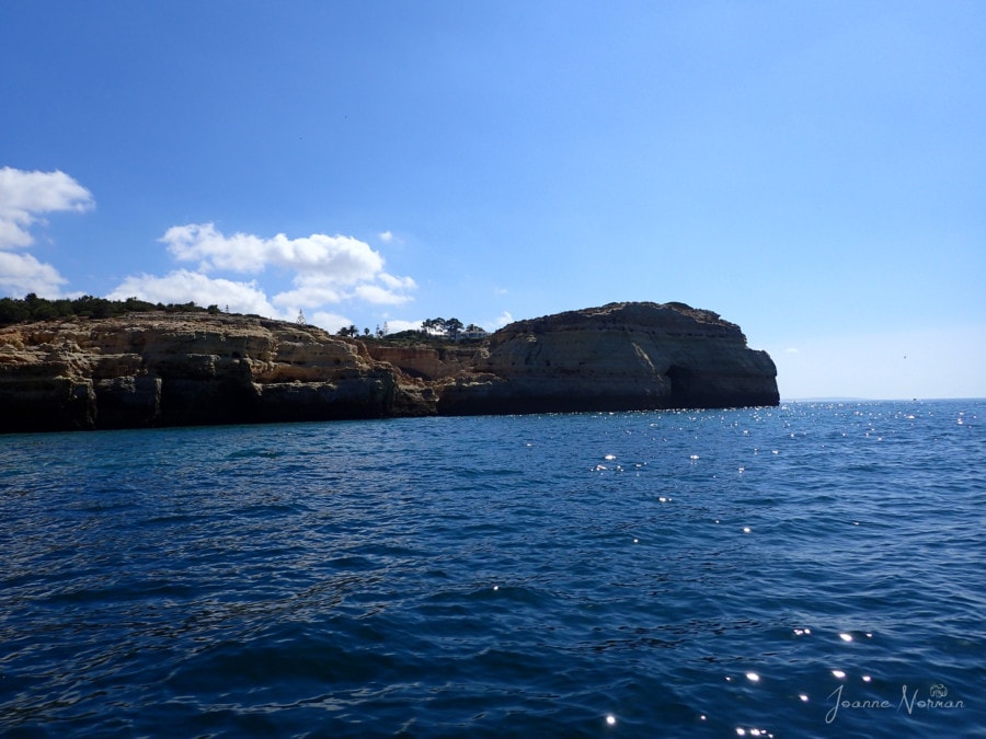 distant view of cliffs on water in Carvoeiro boat tour Algarve