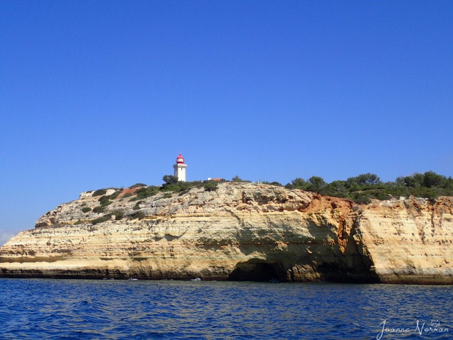 red and white lighthouse on top of sandstone cliffs Carvoeiro Algarve