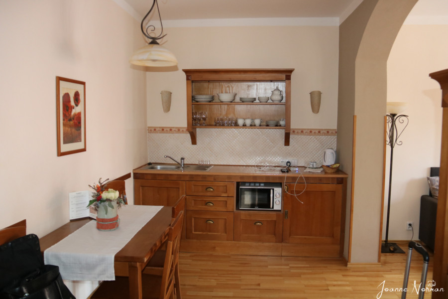 kitchen area of apartment with wooden cupboards and small table cesky krumlov where to stay