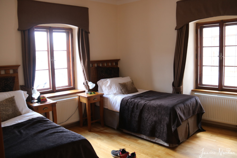 two single beds with black covers and large window cesky krumlov family apartment