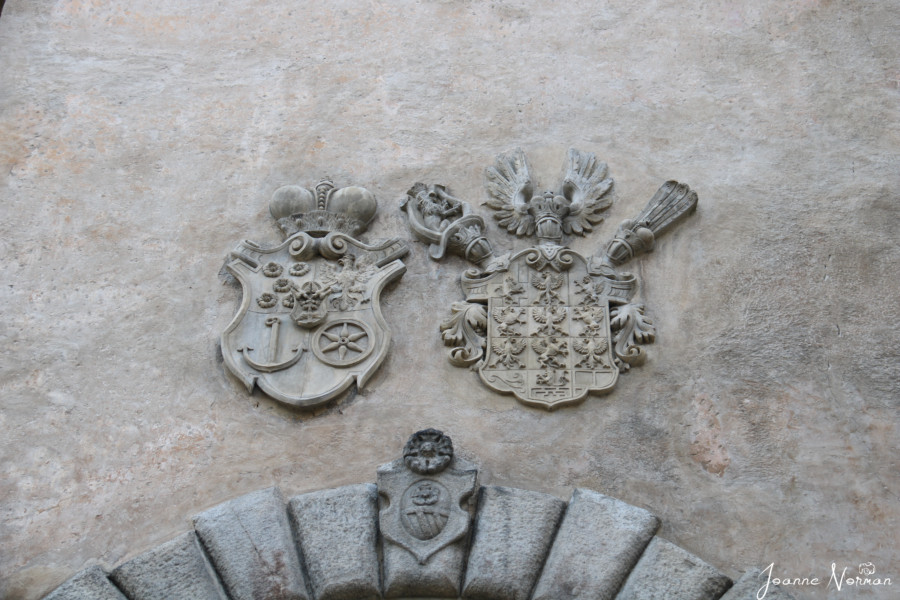 two family crests above castle archway entrance