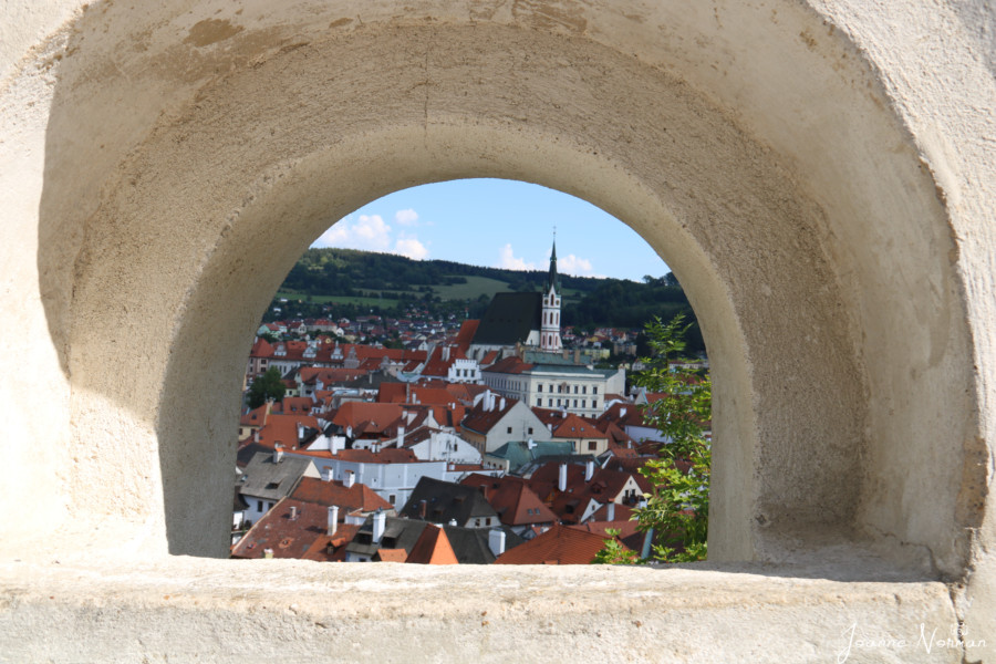 view of cesky krumlov town and st vitus cathedral framed with arched stone window is cool thing to see in cesky krumlov