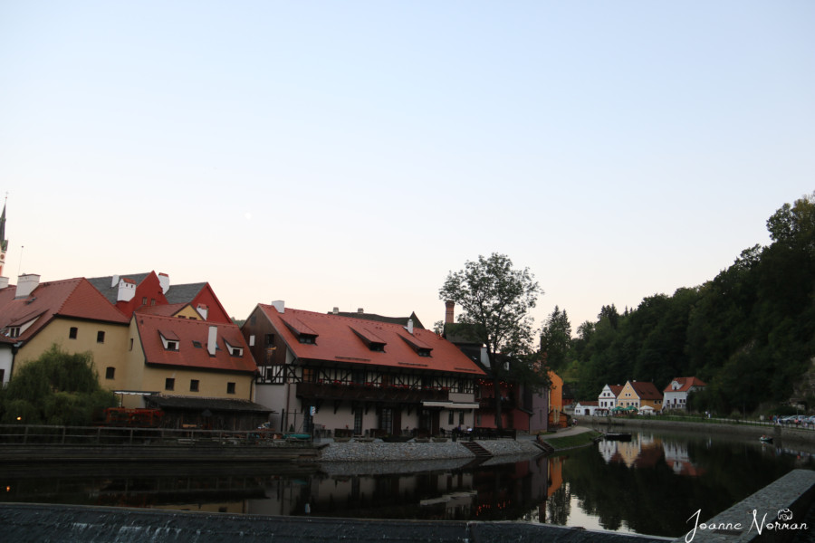 colourful houses on river at dusk with reflection in water is things to do in cesky krumlov