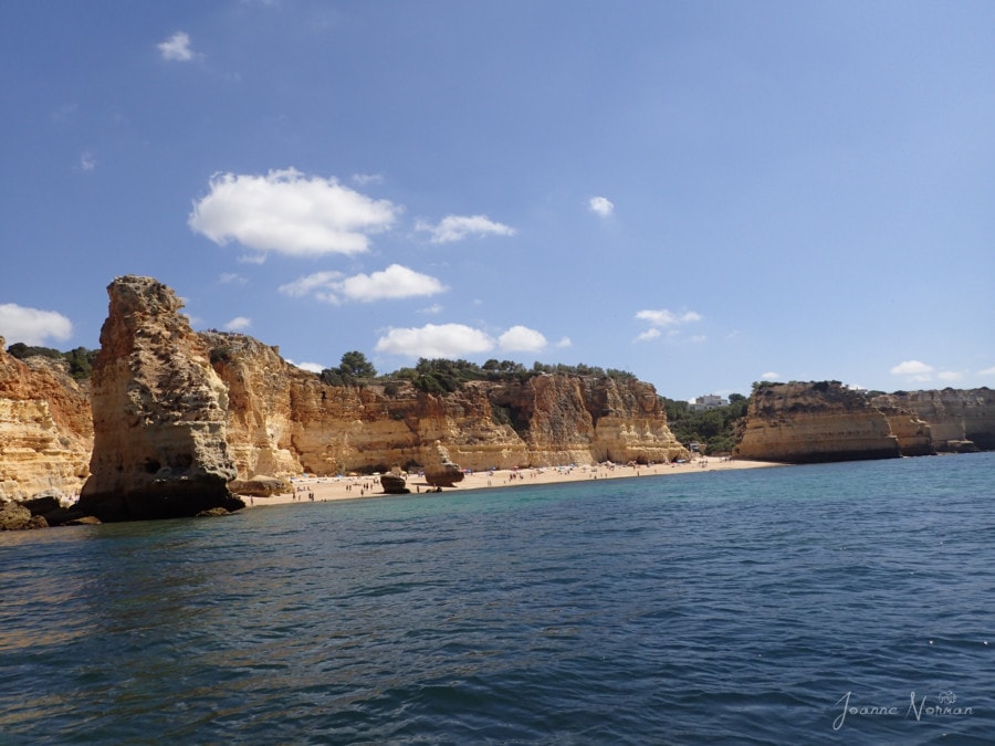 view of ocean and rock formations and beach from boat is Praia da Marinha
