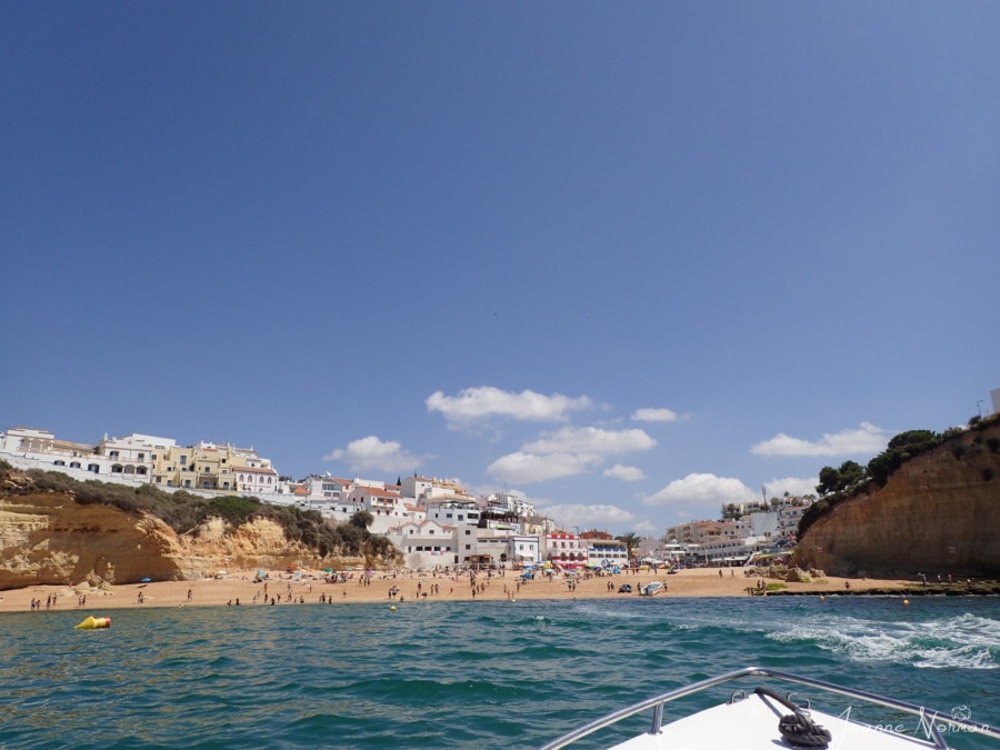view of beach from water with white buildings behind great things to do in Carvoeiro