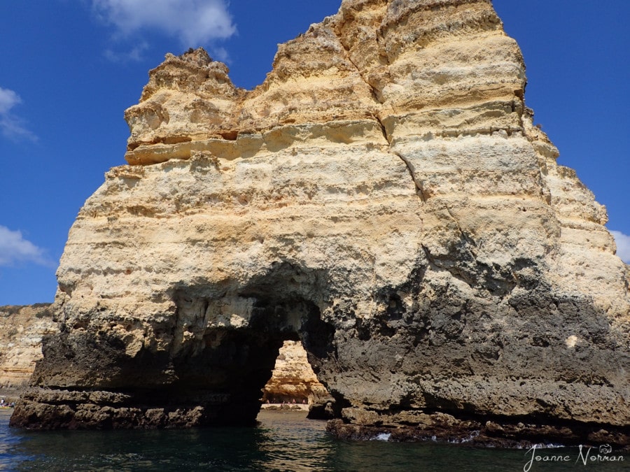 arch shaped limestone rock formation with striation lines Ponta da Piedade