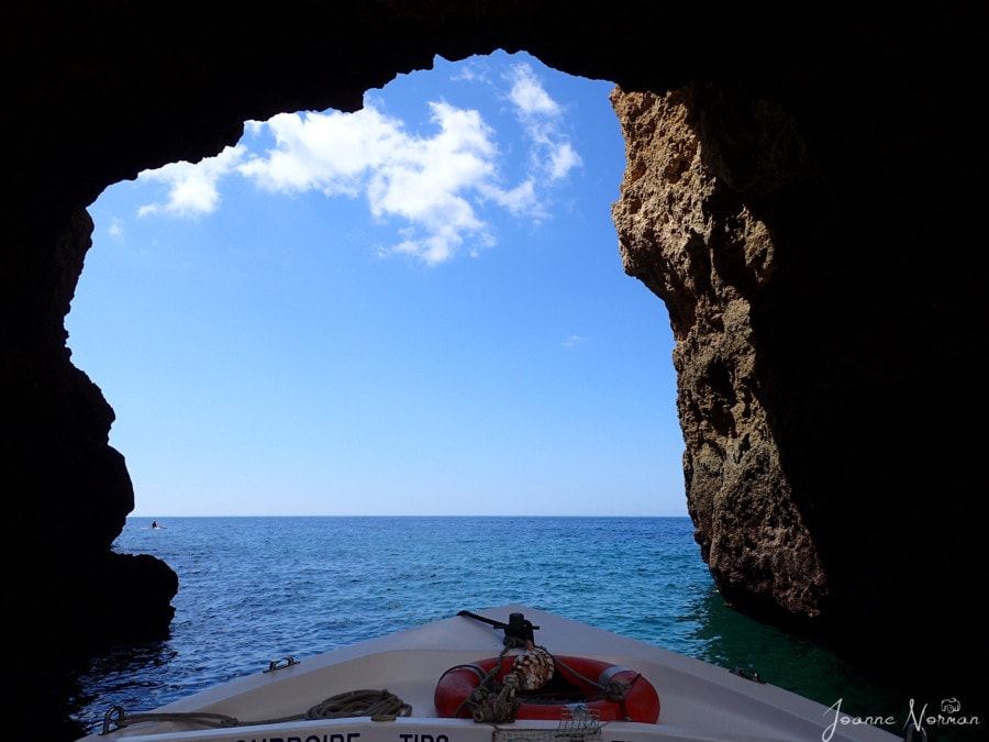 tip of boat exiting cave into blue ocean  Ponta da Piedade Lagos