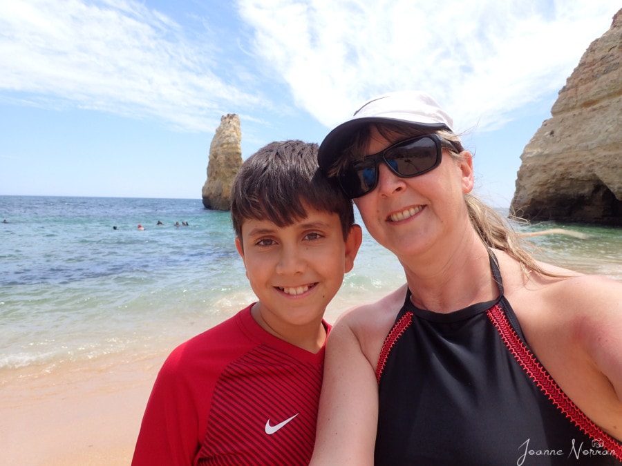 me and Cj doing selfie with large rock formation in ocean behind us at Praia do Carvahlo