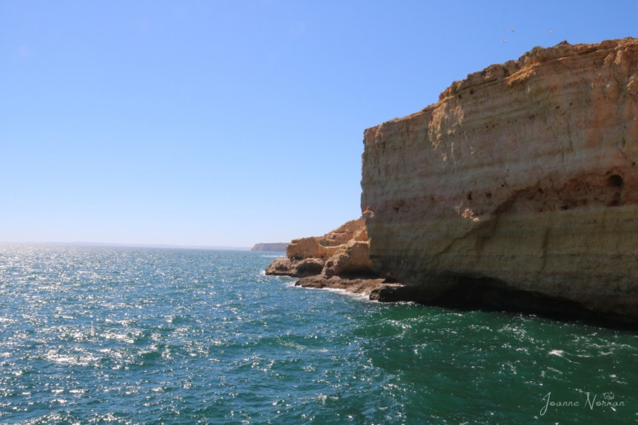 orange cliffs on green ocean