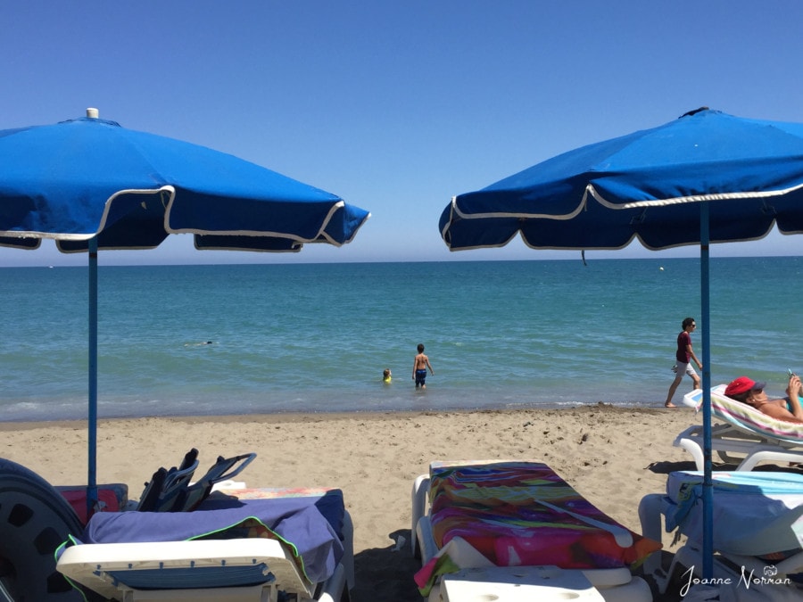 blue sand umbrellas facing sea is great Spain with kids