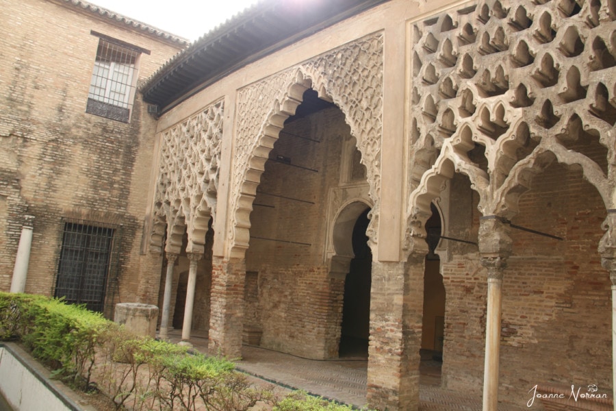 courtyard with sand colored arches in moorish style is alcazar seville Spain holiday destinations