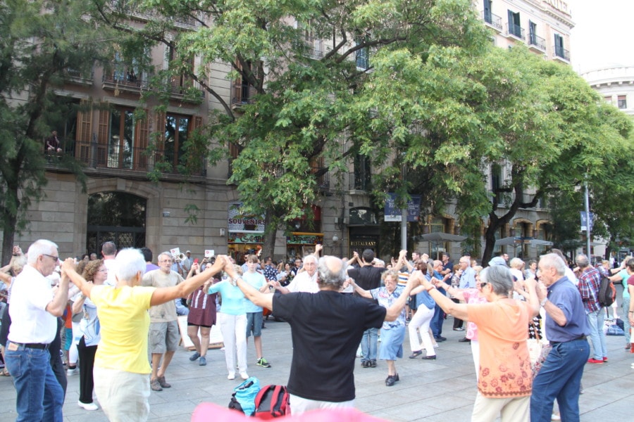 men and women holding hands in circle with people watching is sardana dance things to do in Barcelona with kids