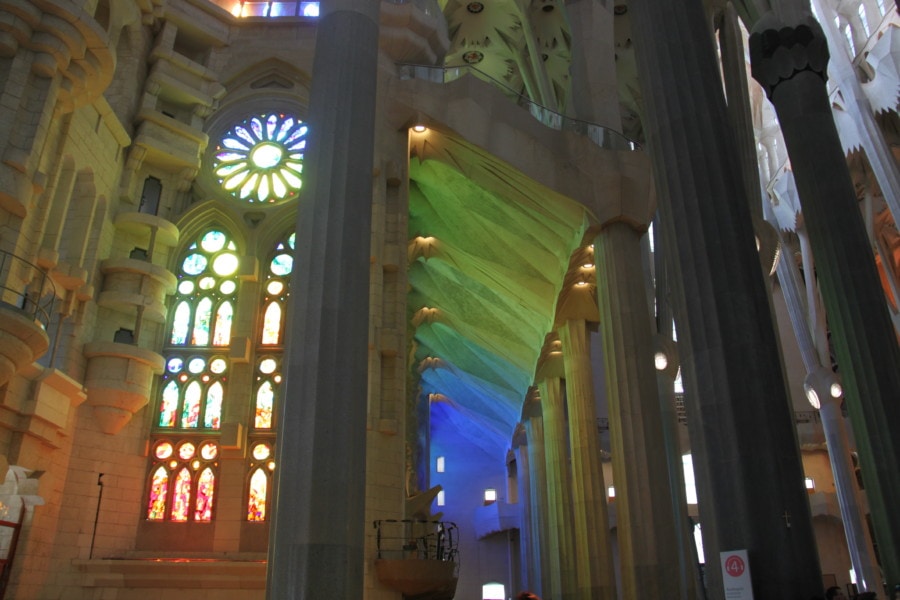 colourful reflections of light from stained glass windows on walls of Sagrada Familia