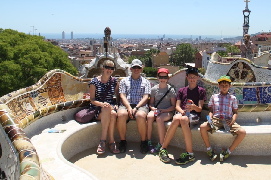 family sitting on colourful bench at Park Guell 3 days in Barcelona