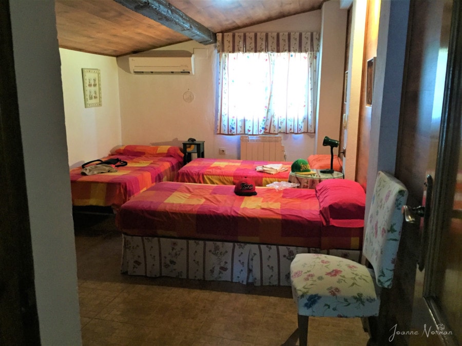 three single beds with red covers on top floor of Granada carmen family Granada with kids