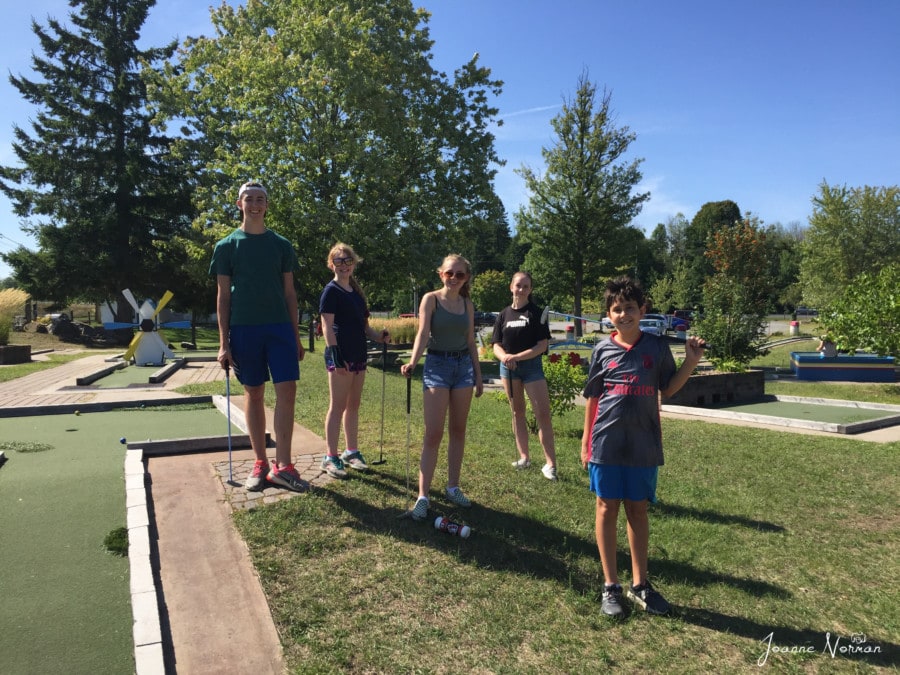 Five teens during Ottawa summer playing minigolf