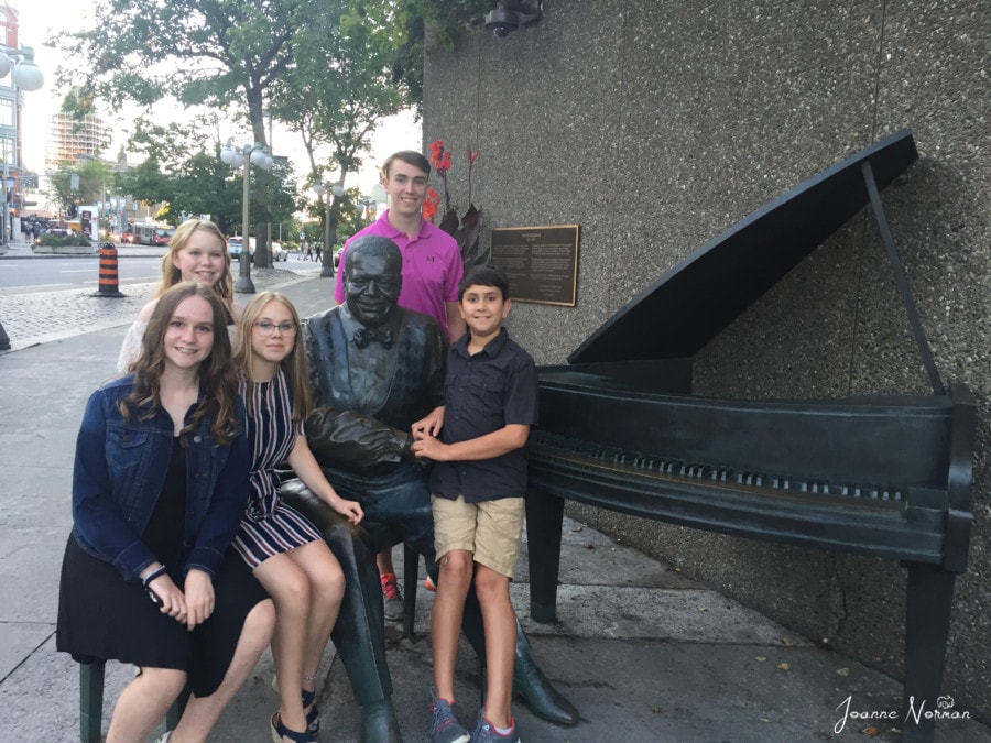 five kids sitting next to Oscar Peterson and piano sculpture things to do in Ottawa with kids