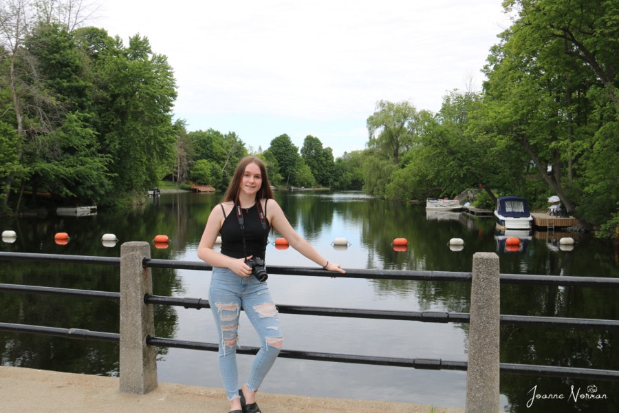 teen girl with black shirt next to railing on dam looking at river Ottawa witih kids