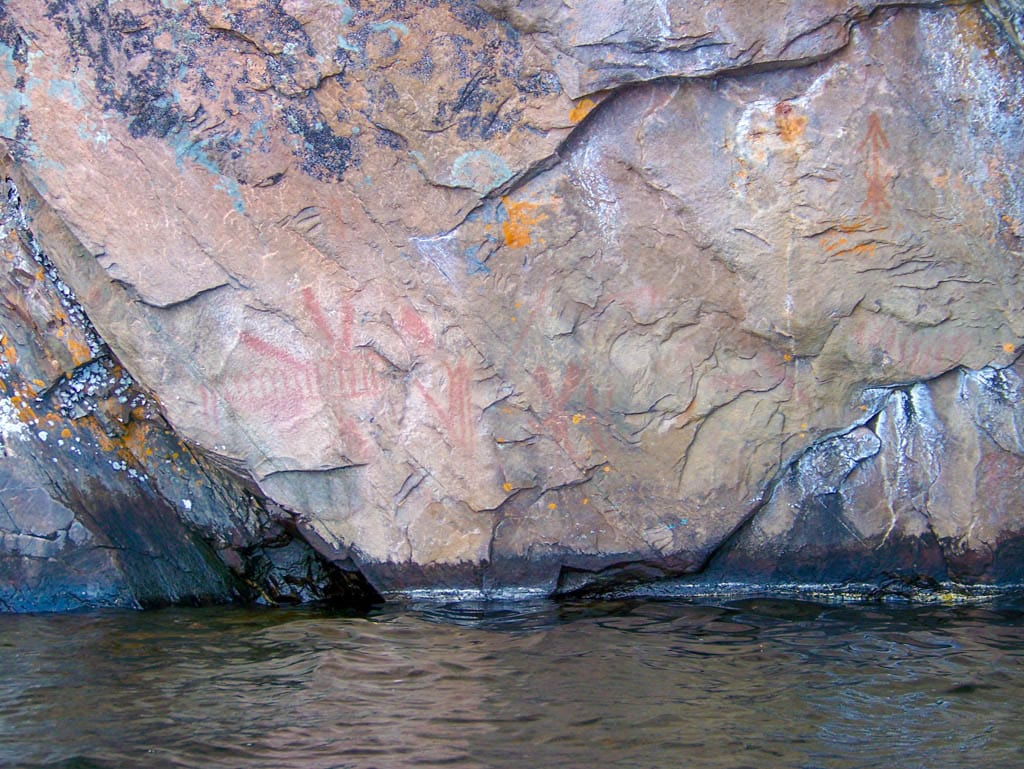 pink rock in water with carvings on it