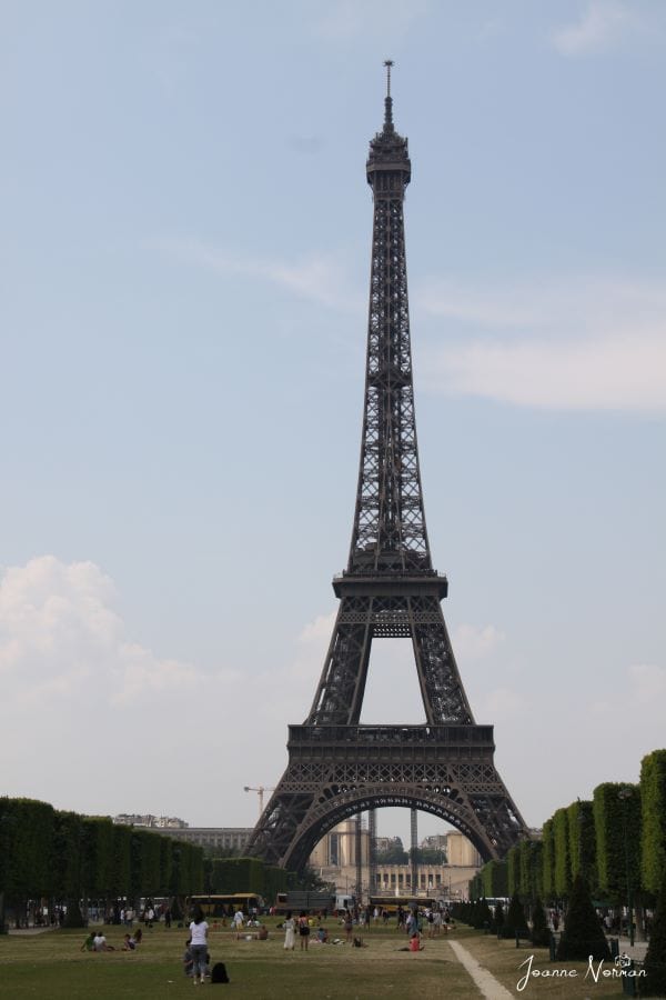 Eiffel tower with large green grass field in front
