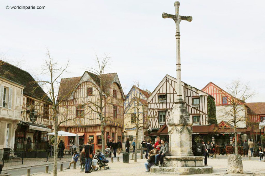 town square with white buildings and tall cross day trip from Paris to Provins