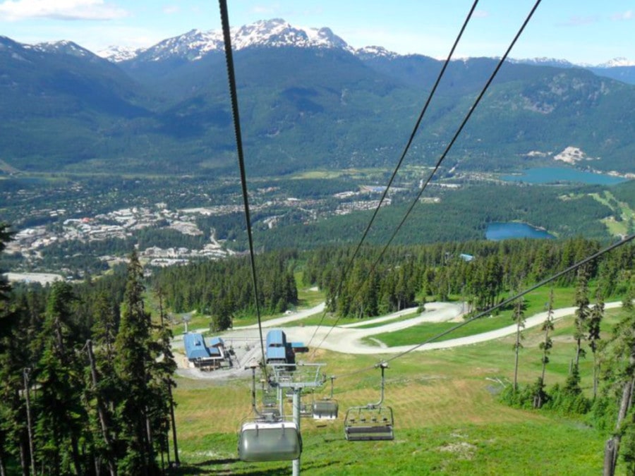 chairlift gondola going up mountain during summer in canada