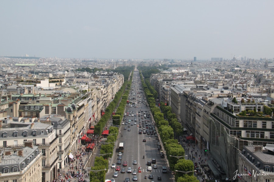 a look down the champs elysees with trees on each side 