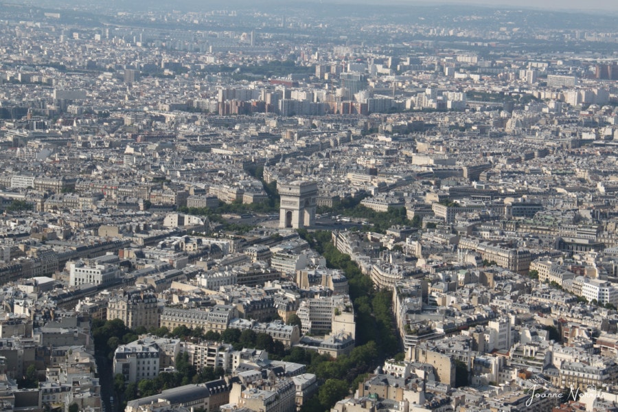 white buildings with Arc de Triomphe towering in center paris itinerary