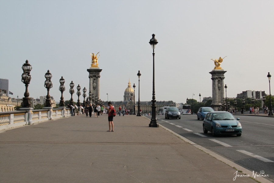 large sidewalk with building of gold capped dome at end