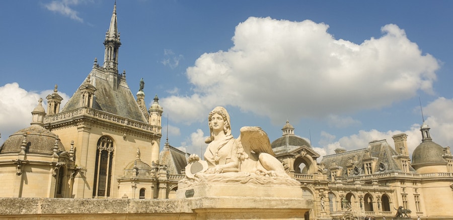 white stone palace day trip from Paris to Chateau de Chantilly