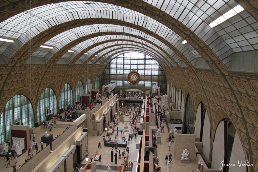 arched glass ceiling over ground floor Musee d'Orsay with statues below Paris holidays