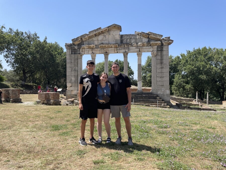 three teens in front of stone pillars in Apollonia
